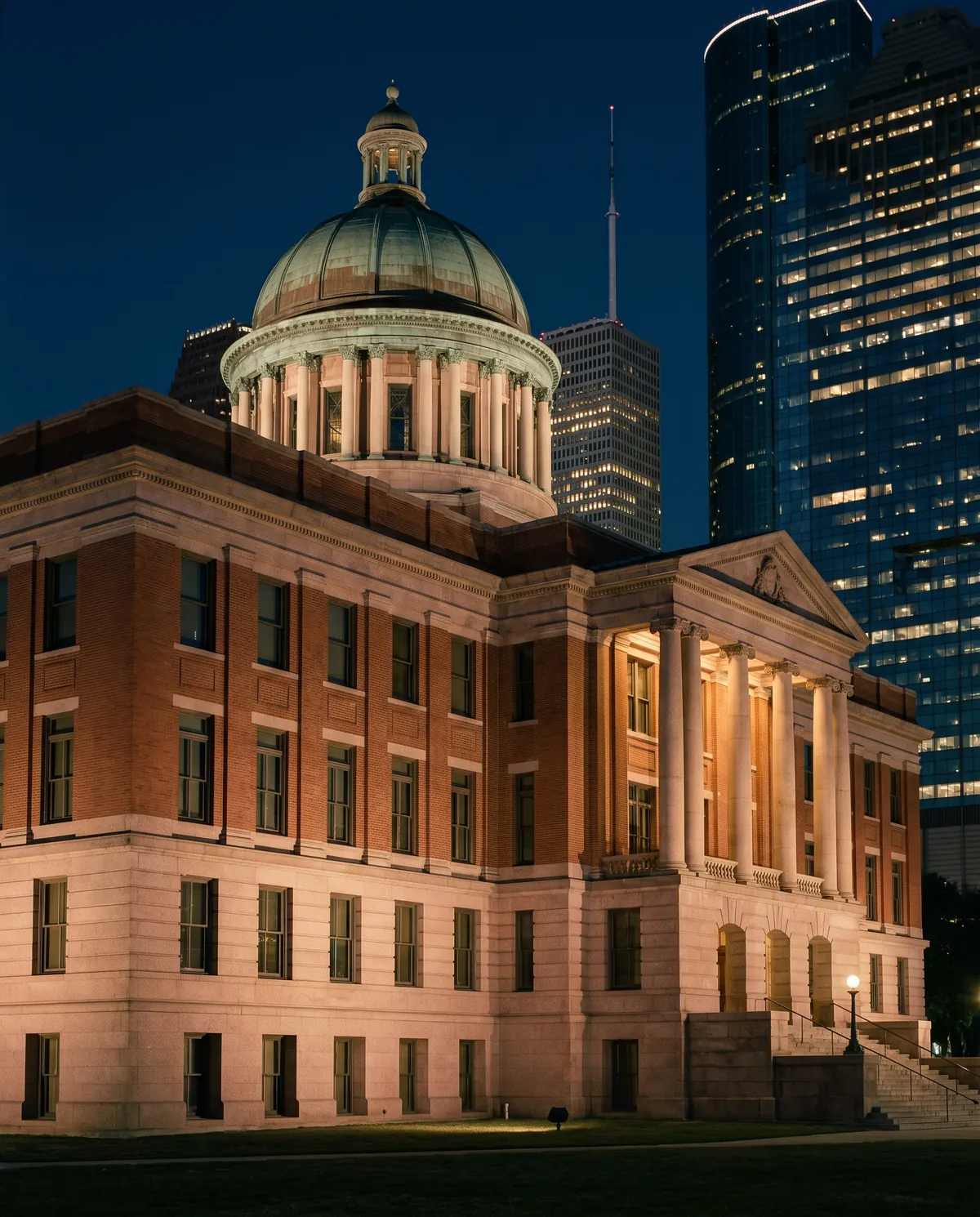 The domed 1910 Harris County Courthouse at dusk below the towers of downtown Houston